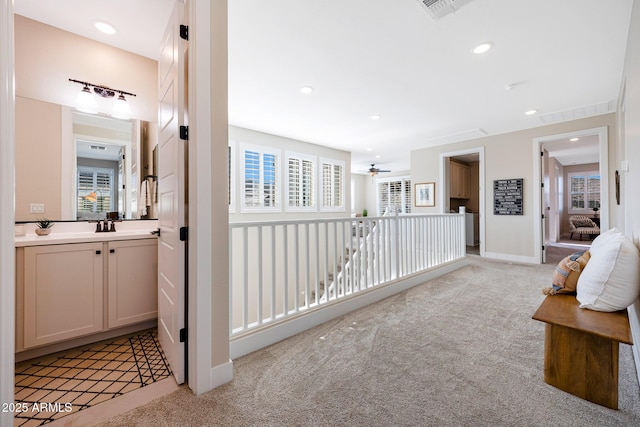 21194 W Hillcrest Blvd, Buckeye, AZ 85396 - corridor featuring light carpet, recessed lighting, baseboards, and a sink