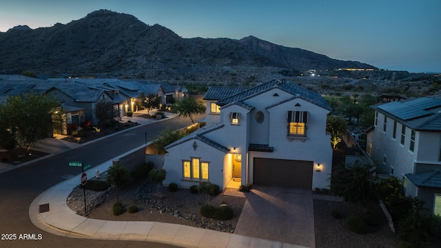 21194 W Hillcrest Blvd, Buckeye, AZ 85396 - mediterranean / spanish-style house with stucco siding, a mountain view, a garage, driveway, and a tiled roof