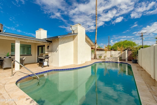 view of swimming pool with a fenced in pool, a patio area, a fenced backyard, and area for grilling