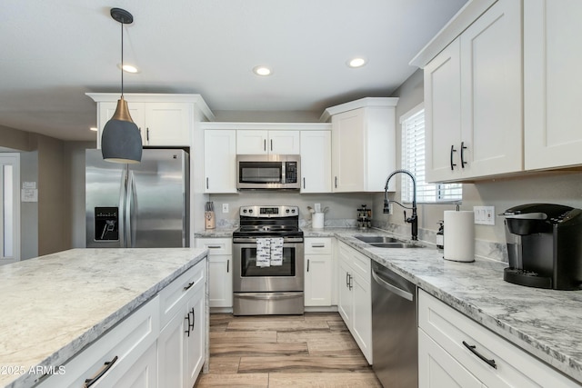 kitchen with stainless steel appliances, a sink, and white cabinets