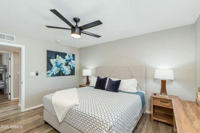 bedroom with visible vents, baseboards, and wood finished floors