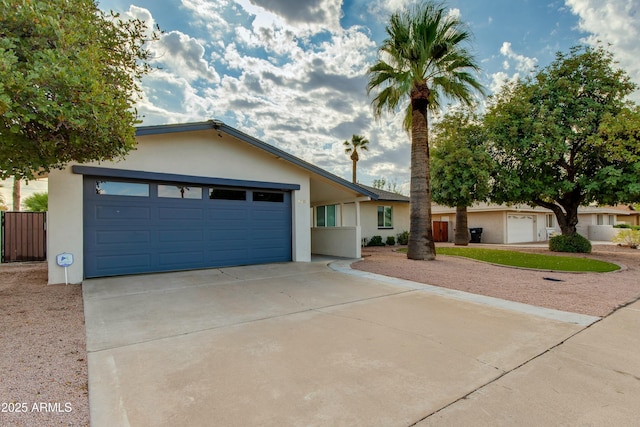 single story home with a garage, concrete driveway, and stucco siding