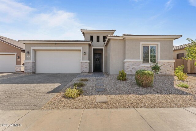 141 S 156th Dr, Goodyear, AZ 85338 - prairie-style house featuring stone siding, a garage, a tile roof, stucco siding, and decorative driveway