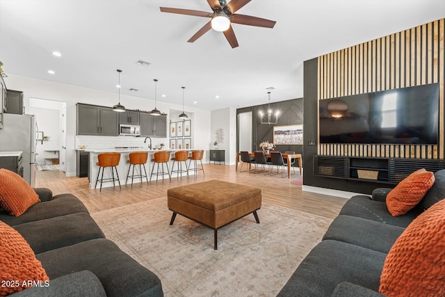 141 S 156th Dr, Goodyear, AZ 85338 - living room featuring baseboards, recessed lighting, visible vents, light wood finished floors, and ceiling fan with notable chandelier