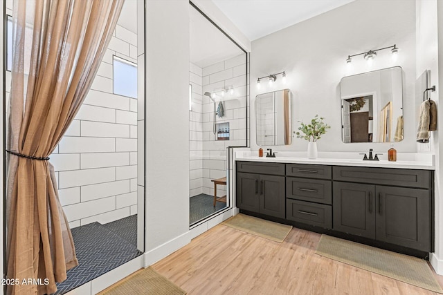 141 S 156th Dr, Goodyear, AZ 85338 - full bathroom featuring wood finished floors, double vanity, a sink, and walk in shower