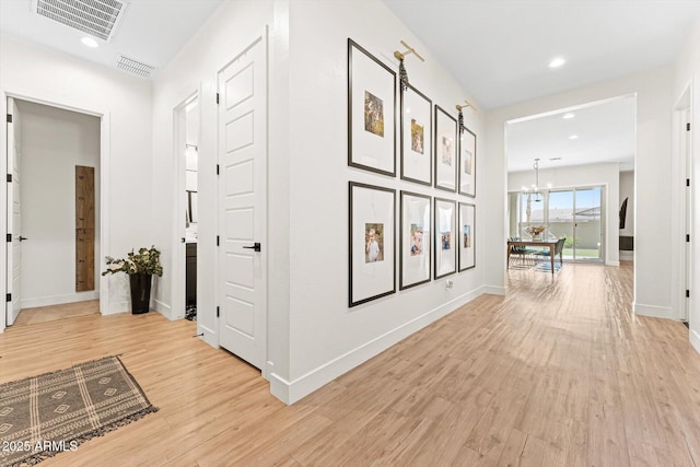 141 S 156th Dr, Goodyear, AZ 85338 - hallway featuring light wood-style flooring, baseboards, a notable chandelier, and visible vents