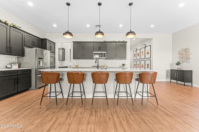 141 S 156th Dr, Goodyear, AZ 85338 - kitchen featuring stainless steel appliances, light countertops, a sink, and decorative backsplash