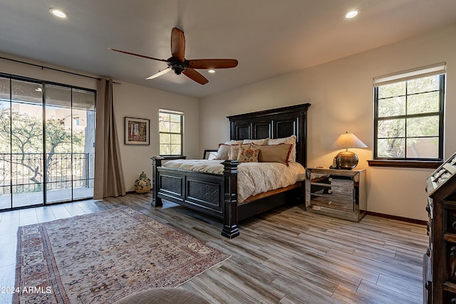 bedroom with access to exterior, wood-type flooring, multiple windows, and ceiling fan