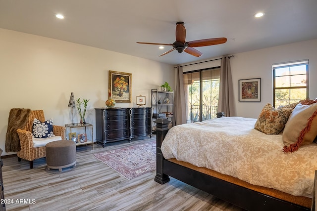 bedroom with access to exterior, hardwood / wood-style floors, multiple windows, and ceiling fan