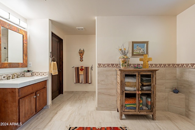 bathroom with vanity and tile walls