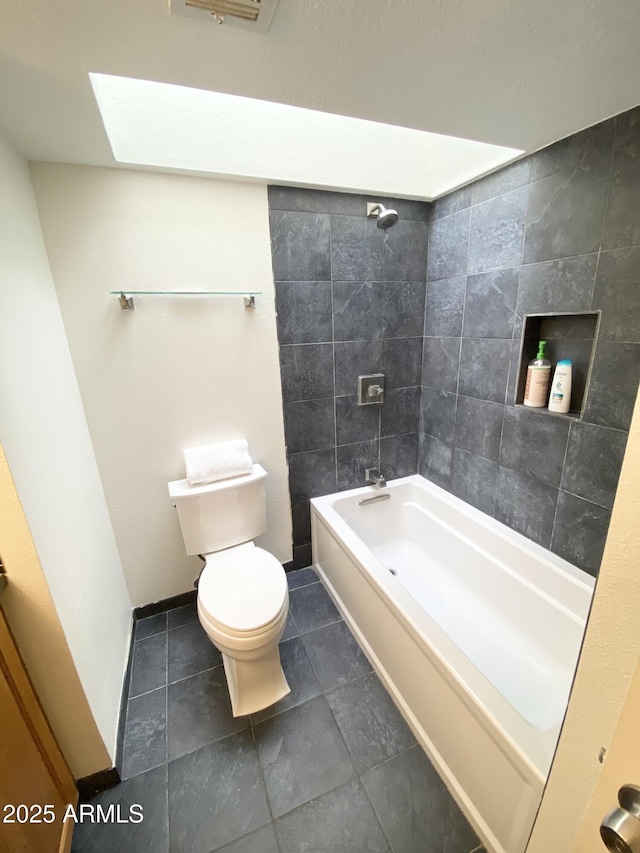 full bathroom with toilet, a skylight, washtub / shower combination, and baseboards