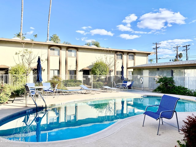 community pool featuring a patio area and fence