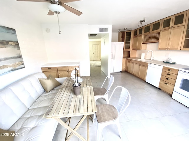 kitchen featuring light countertops, white appliances, a sink, and visible vents