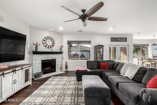 living room featuring ceiling fan, dark hardwood / wood-style floors, a fireplace, and french doors