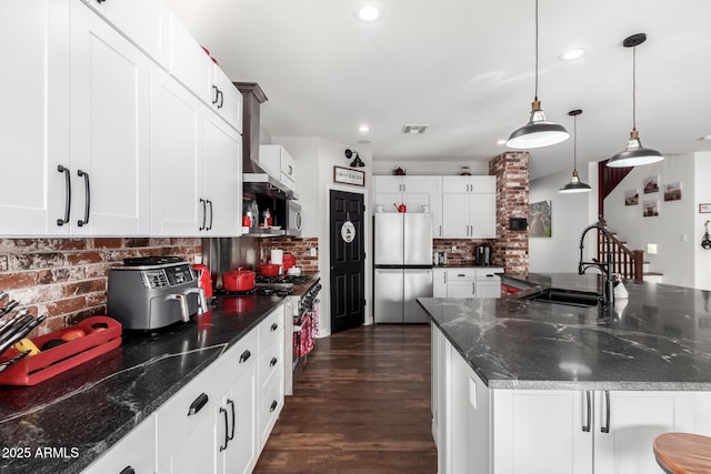 kitchen with sink, stainless steel appliances, backsplash, decorative light fixtures, and white cabinets