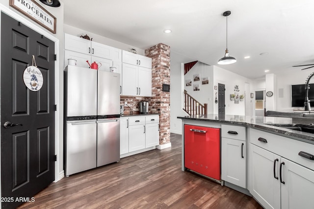 kitchen with stainless steel refrigerator, white cabinetry, dark stone countertops, and pendant lighting