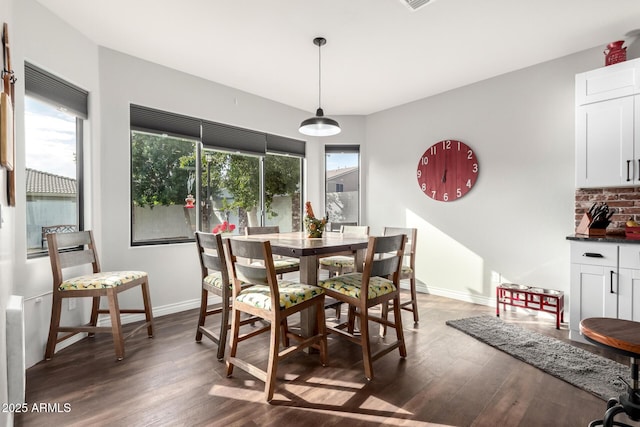 dining room featuring a healthy amount of sunlight and dark hardwood / wood-style flooring