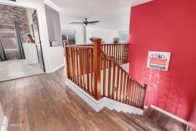 stairs with hardwood / wood-style flooring and ceiling fan