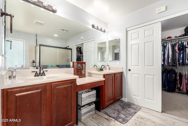 bathroom featuring hardwood / wood-style floors, vanity, and a shower with shower door