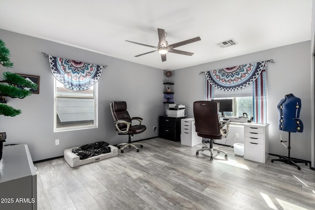 home office with light wood-type flooring and ceiling fan