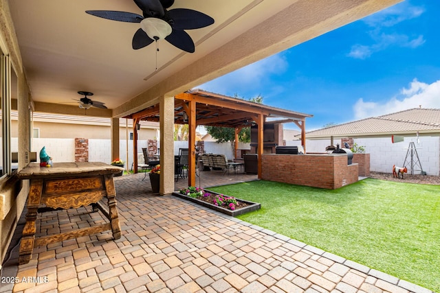 view of patio featuring ceiling fan and an outdoor kitchen