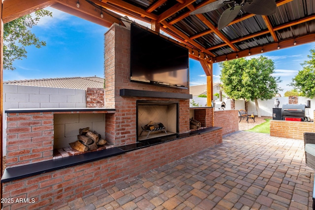 view of patio with an outdoor brick fireplace and ceiling fan