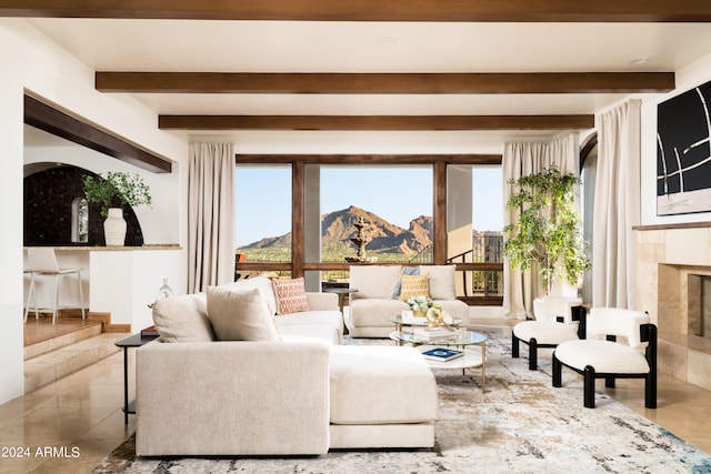 living room with beamed ceiling, a tile fireplace, and tile patterned floors