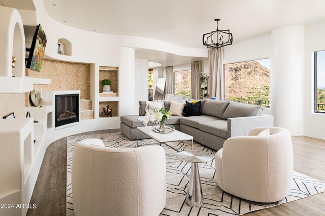 4636 E Moonlight Way, Paradise Valley, AZ 85253 - living area with light wood-style flooring, a chandelier, and a tiled fireplace