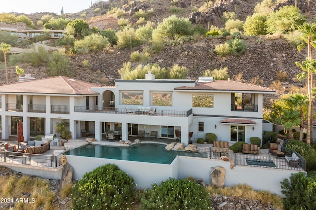 rear view of property featuring a patio area, outdoor lounge area, and a balcony