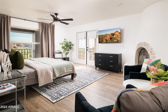 bedroom with access to exterior, light hardwood / wood-style flooring, multiple windows, and ceiling fan