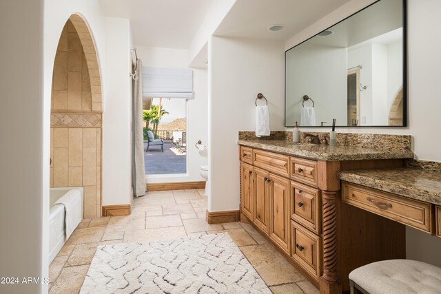 4636 E Moonlight Way, Paradise Valley, AZ 85253 - bathroom with stone tile flooring, vanity, toilet, and baseboards