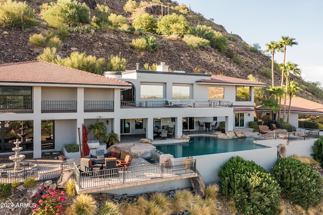 4636 E Moonlight Way, Paradise Valley, AZ 85253 - rear view of house featuring outdoor lounge area, a balcony, a patio, stucco siding, and an outdoor pool