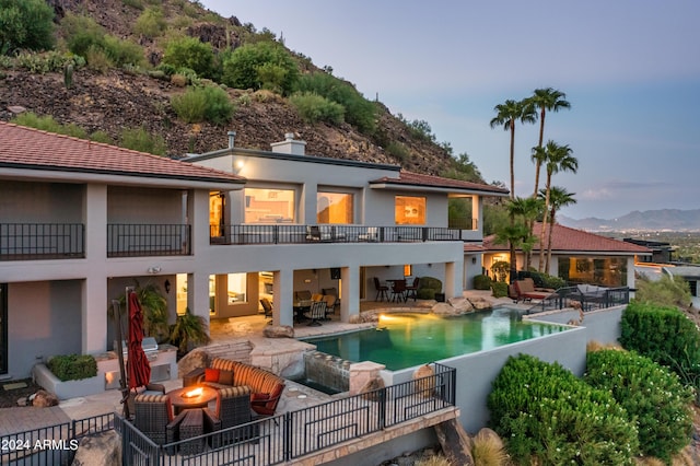 4636 E Moonlight Way, Paradise Valley, AZ 85253 - back of property featuring a mountain view, an outdoor living space with a fire pit, a patio area, a balcony, and stucco siding