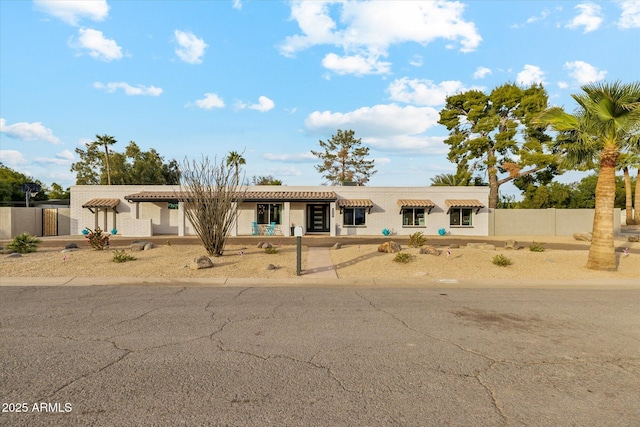 view of front of house with a tile roof and fence