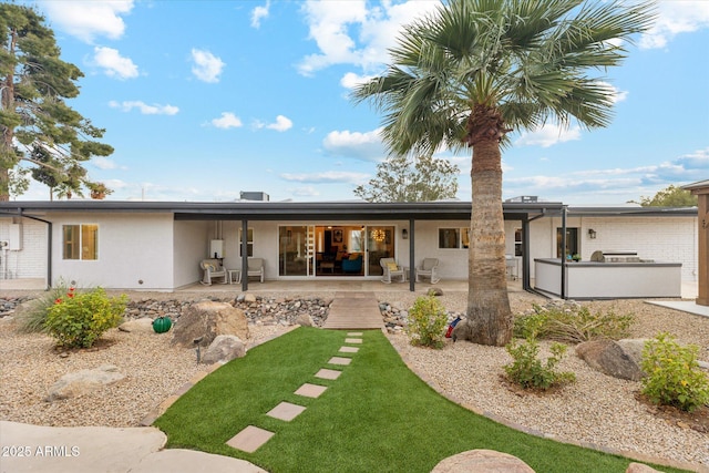 back of property with a patio area and stucco siding