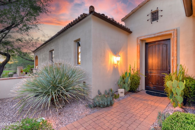 view of exterior entry at dusk