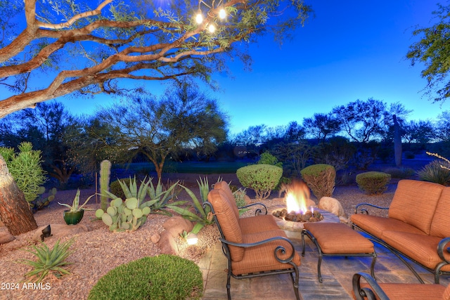 patio terrace at dusk featuring an outdoor fire pit