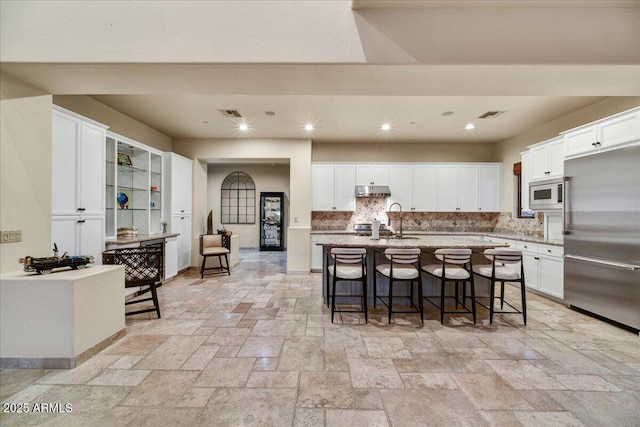 2744 S First Water Ln, Gold Canyon, AZ 85118 - kitchen featuring built in appliances, a breakfast bar, and white cabinetry