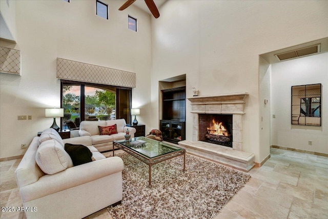 2744 S First Water Ln, Gold Canyon, AZ 85118 - living room with stone finish flooring, a ceiling fan, a premium fireplace, baseboards, and visible vents