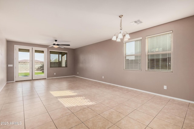 tiled empty room featuring ceiling fan with notable chandelier