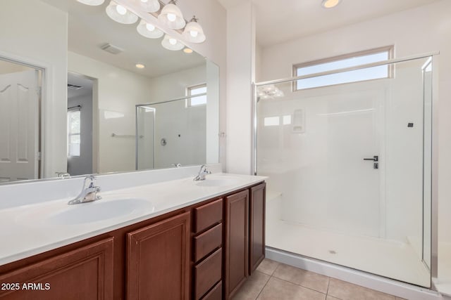 bathroom with a shower with shower door, vanity, and tile patterned flooring