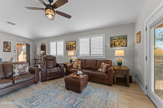 living room with light hardwood / wood-style flooring and ceiling fan