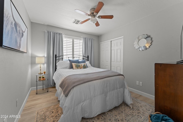 bedroom featuring a closet, light hardwood / wood-style floors, and ceiling fan