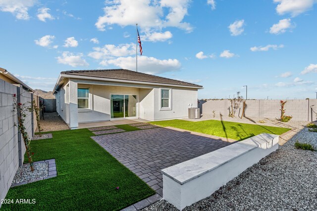 rear view of property featuring a patio, central AC, and a lawn