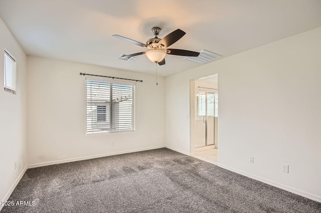 carpeted spare room featuring ceiling fan and a healthy amount of sunlight