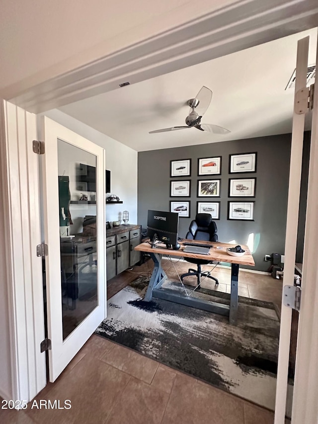 tiled home office featuring ceiling fan