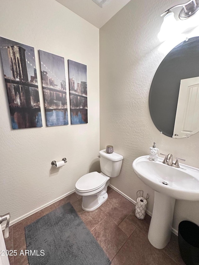 bathroom with toilet, tile patterned floors, and sink