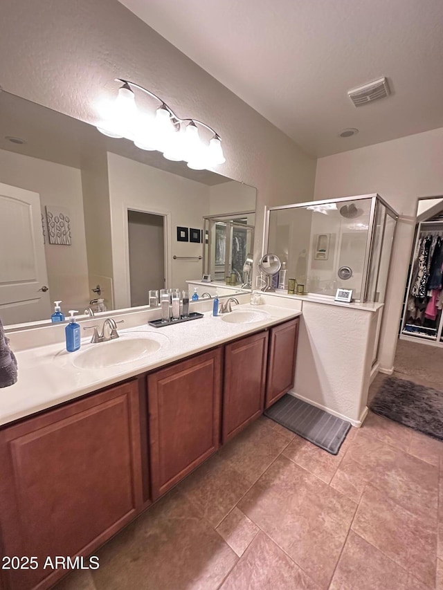 bathroom with vanity, tile patterned floors, and a shower with door