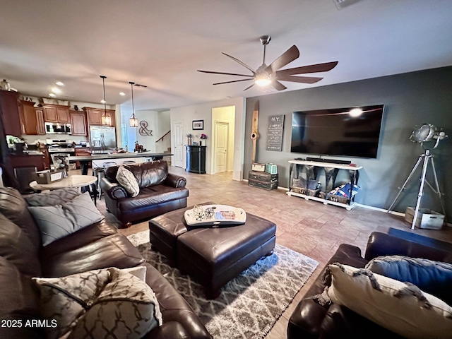 living room featuring ceiling fan with notable chandelier