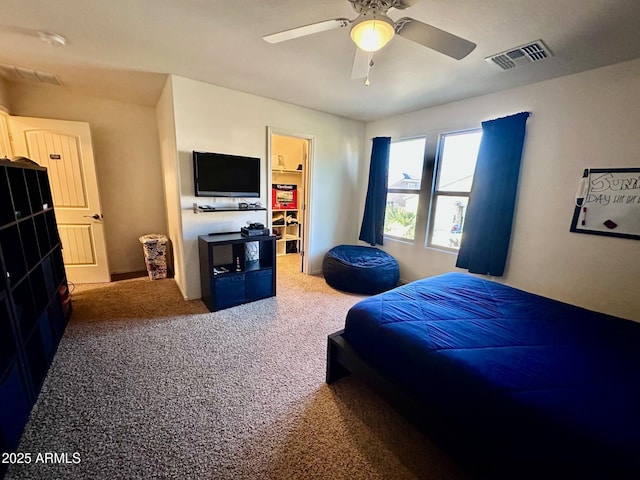 bedroom with carpet floors, a spacious closet, and ceiling fan